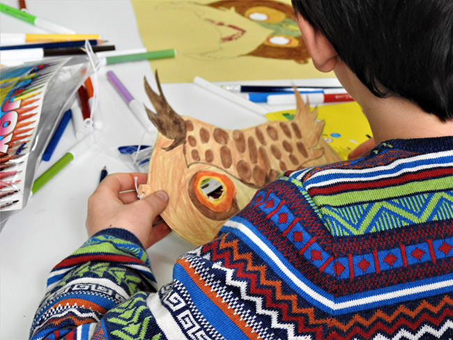 Un niño con una máscara de búho, en un taller de Brinzal en su fiesta de aniversario (foto: Patricia Catalina Allueva).
