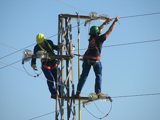 Dos operarios de una compañía eléctrica corrigen un tendido peligroso para las aves (foto: Justo Martín).

