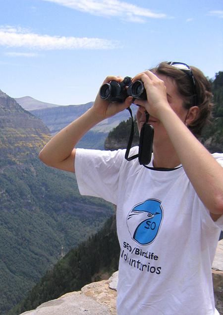 Una joven observa aves con sus binoculares (foto: SEO/BirdLife).

